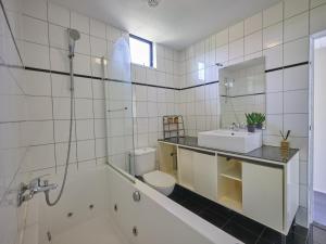 a bathroom with a tub and a toilet and a sink at Brabants licht in Lage Mierde +37 photos