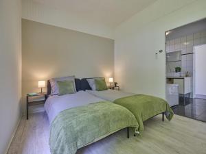 a bedroom with a large bed with two green blankets at Brabants licht in Lage Mierde