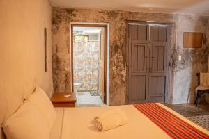a bedroom with a bed and a door to a bathroom at Charming Yellow Colonial House in the Downtown in Valladolid