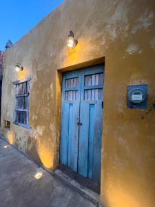 a building with a blue door and two windows at Charming Yellow Colonial House in the Downtown in Valladolid +13 photos