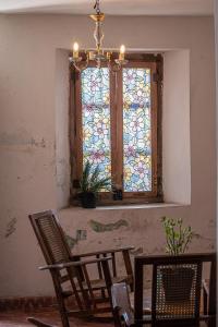a window with a chandelier and chairs in a room at Charming Yellow Colonial House in the Downtown in Valladolid