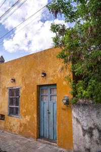 a yellow building with a blue door on a street at Charming Yellow Colonial House in the Downtown in Valladolid