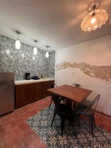 a kitchen with a table and chairs and a counter at Charming Yellow Colonial House in the Downtown in Valladolid