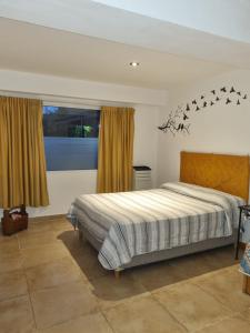 a bedroom with a bed with birds on the wall at El Encuentro in Sierra de los Padres