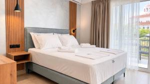a bedroom with a large bed with white sheets and a window at Studios Maria - Renovating Brand New for 2026 in Potos +60 photos
