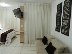 Life Resort في برازيليا: غرفة معيشة مع سرير وأريكة وتلفزيون