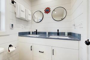 a bathroom with two sinks and two mirrors at Trails & Tranquility in Pagosa Springs
