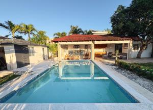 a swimming pool in front of a house at Villa La Dueña Las Terrenas in Las Terrenas