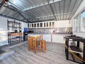 a kitchen with white cabinets and a table and stool at Villa La Dueña Las Terrenas in Las Terrenas