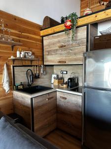 a kitchen with wooden cabinets and a stainless steel refrigerator at Meris in Ulcinj +32 photos