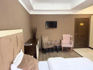 a hotel room with a bed and a table and chairs at Monroe Hotel in Almaty +46 photos