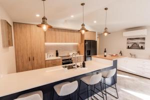 a kitchen with a large counter with bar stools at Alpine | BBQ & Fireplace | Table Tennis - HS68319 in Hanmer Springs