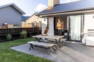 a man and a woman standing on a patio with a table at Alpine | BBQ & Fireplace | Table Tennis - HS68319 in Hanmer Springs