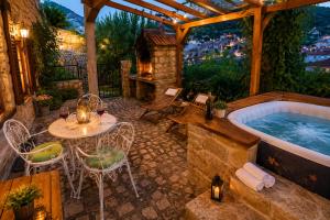a patio with a tub and a table and chairs at Rustic Garden & Jacuzzi Retreat in Vis
