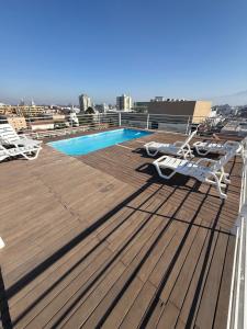 a deck with chairs and a swimming pool on a roof at Hermoso Depto Central in Rancagua