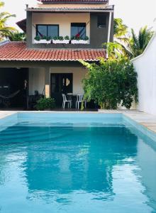 a house with a swimming pool in front of a house at Casasukyara in Amontada