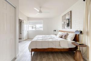 a white bedroom with a bed and a ceiling fan at Oasi Elegante in Scottsdale