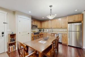 a kitchen with a wooden table and stainless steel refrigerator at Base Camp One 403 in Granby