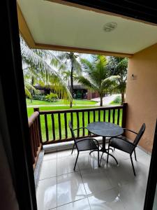 a patio with a table and chairs on a balcony at VG Cumbuco J&Y in Caucaia