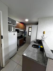 a kitchen with a sink and a white refrigerator at VG Cumbuco J&Y in Caucaia +8 photos