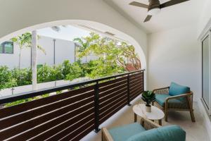 a balcony with a window and two chairs and a table at The Reserve - Boca Designer Pool Suite in Boca Raton