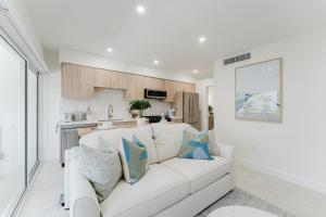 a white living room with a white couch and a kitchen at The Reserve - Boca Designer Pool Suite in Boca Raton +36 photos