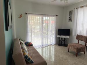 a living room with a couch and a television at Cabaña Mar Olon Renovation in Olón