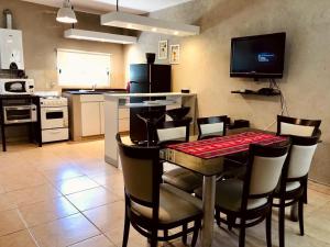 a kitchen and dining room with a table and chairs at La Casita de la Granja, Casa con Pileta Y Gran Parque in La Granja
