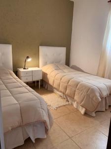 two beds sitting next to each other in a room at La Casita de la Granja, Casa con Pileta Y Gran Parque in La Granja +4 photos