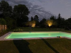 a swimming pool in a yard at night at La Casita de la Granja, Casa con Pileta Y Gran Parque in La Granja