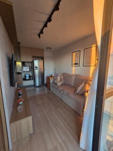 a living room with a couch and a kitchen at Vista Mar Icaraí Ingá in Niterói