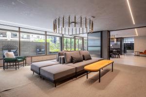 a living room with a couch and a chandelier at On Jurupis - Livinn by Travel Inn OJ1 in São Paulo