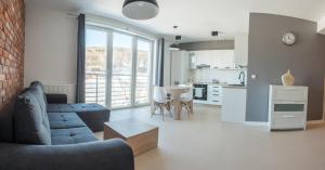 sala de estar con sofá azul y cocina en MINIMAR Apartamenty Świeradów, en Świeradów-Zdrój