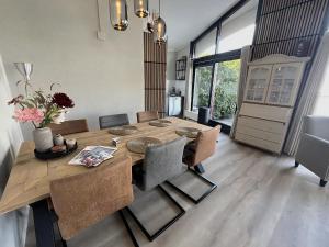 a dining room with a wooden table and chairs at Aquaronde 108 in Lemmer