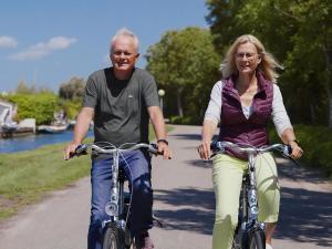a man and a woman riding bikes down a path at Aquaronde 108 in Lemmer