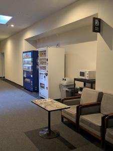 a room with a couch and a table and a refrigerator at Fuji Mountain Resort Hotel in Fujikawaguchiko +8 photos