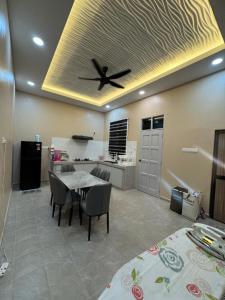 a kitchen with a table and a ceiling fan at Private Pool Homestay Kota Bharu 3 Bilik Tidur Muat 12 Tetamu in Kota Bharu