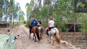 three people riding horses down a dirt road at Cabañas Mastranto in Monterrey