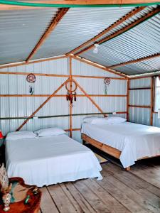 two beds in a room with white sheets at Cabañas Mastranto in Monterrey