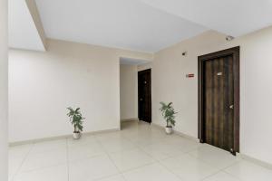 a hallway with two potted plants in a building at Hotel O Noida premium inn in Noida