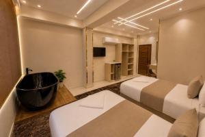 a hotel room with two beds and a bathtub at Vincci Pyramids View in Cairo