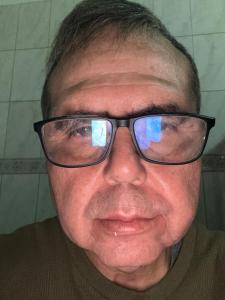 a man wearing glasses is smiling at the camera at Apartamento in Ribeirão Preto