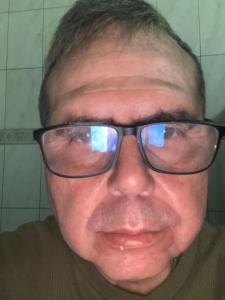 a man with glasses is smiling at the camera at Apartamento in Ribeirão Preto
