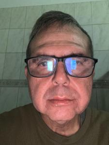 an older man wearing glasses with the reflection at Apartamento in Ribeirão Preto