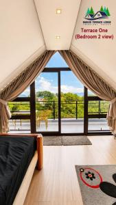 a bedroom with a bed and a large window at Baguio Terrace Lodge in Baguio