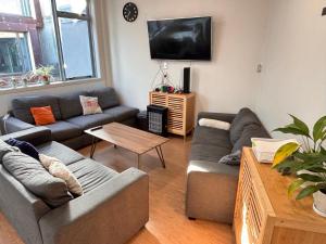 a living room with couches and a flat screen tv at Newton Lodge Auckland in Auckland