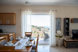 a dining room with a table and a large window at Oasis Sea view suit in Agia Marina Mikrolimanou