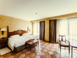 a hotel room with two beds and a chair at Hotel Maher in Cintruénigo