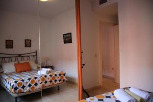 1 dormitorio con cama y espejo en Apartamento Judería Lirio alto, en Sevilla