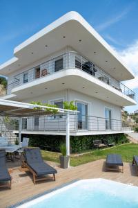 a large white house with a pool in front of it at Oasis Sea view suit in Agia Marina Mikrolimanou